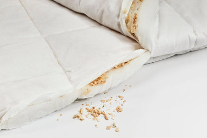 Geöffnete Zirbendecke Light mit sichtbarer Füllung aus Tencel und Zirbenflocken, Bezug aus naturweißer Baumwolle – ideal für leichte, atmungsaktive Schlafdecken