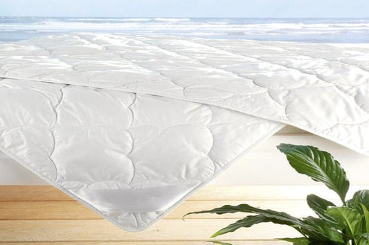 Leichte Sommerdecke aus Leinen und Wildseide, gefaltet auf Holzboden, atmungsaktiv und anschmiegsam